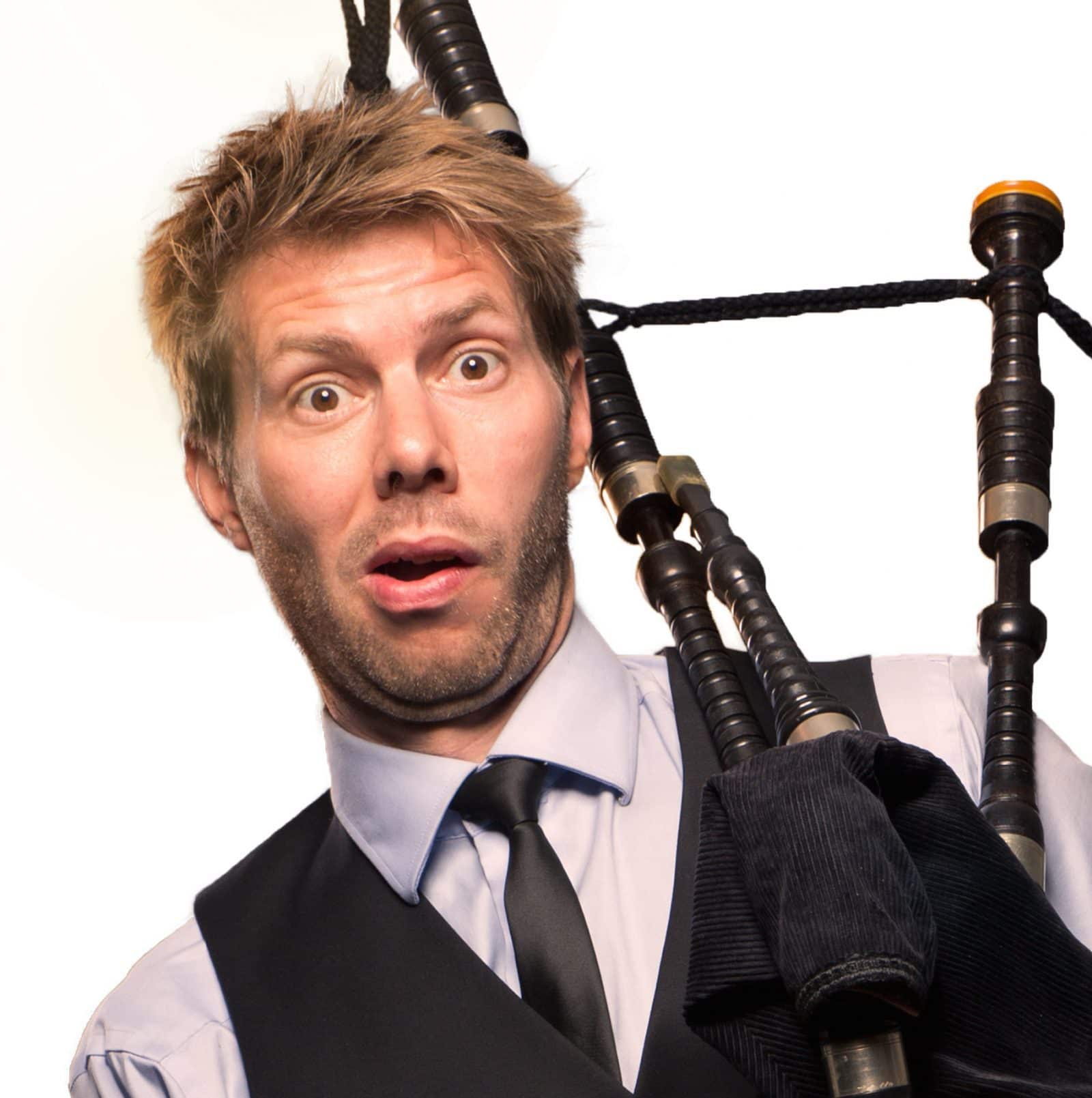 Claus Reiss med sækkepibe og hvid baggrund