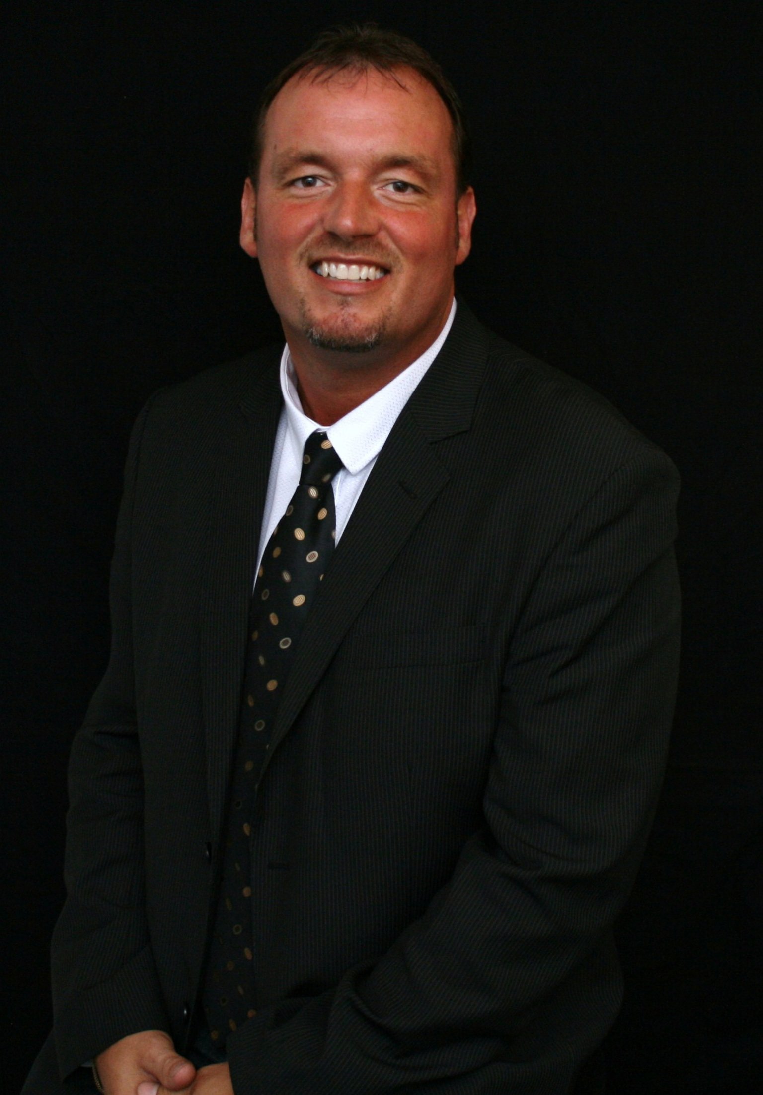 DJ Bryan i jakkesæt med sort baggrund