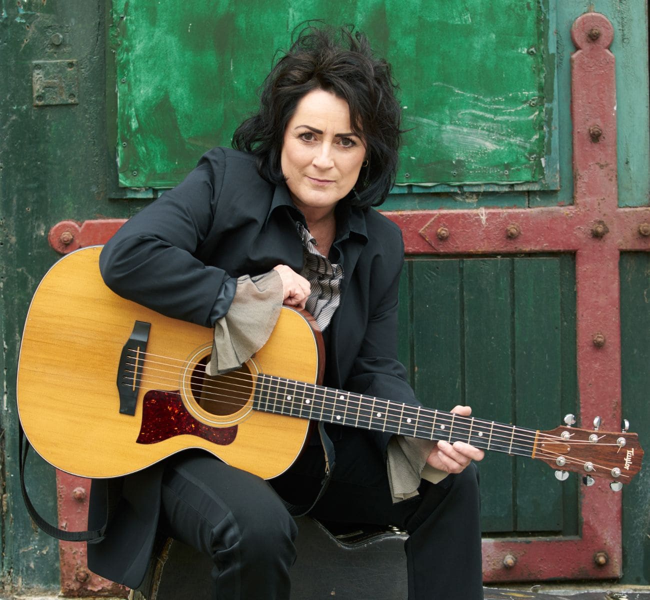 Ester Brohus med guitar og sidder ned