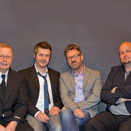 Fester Kester siddende ved grå baggrund