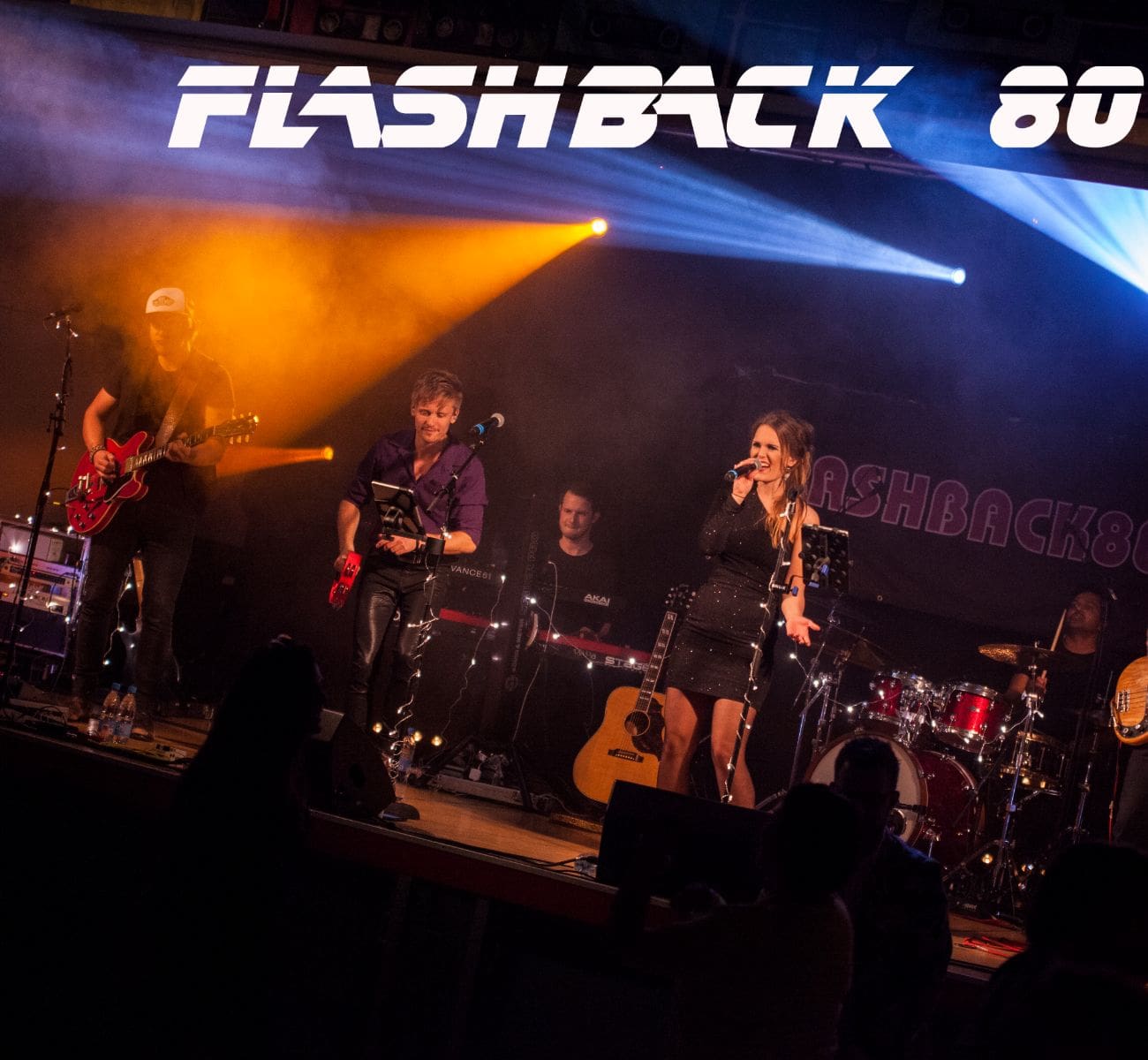 Flashback 80s synger og spiller med orange og blåt lys