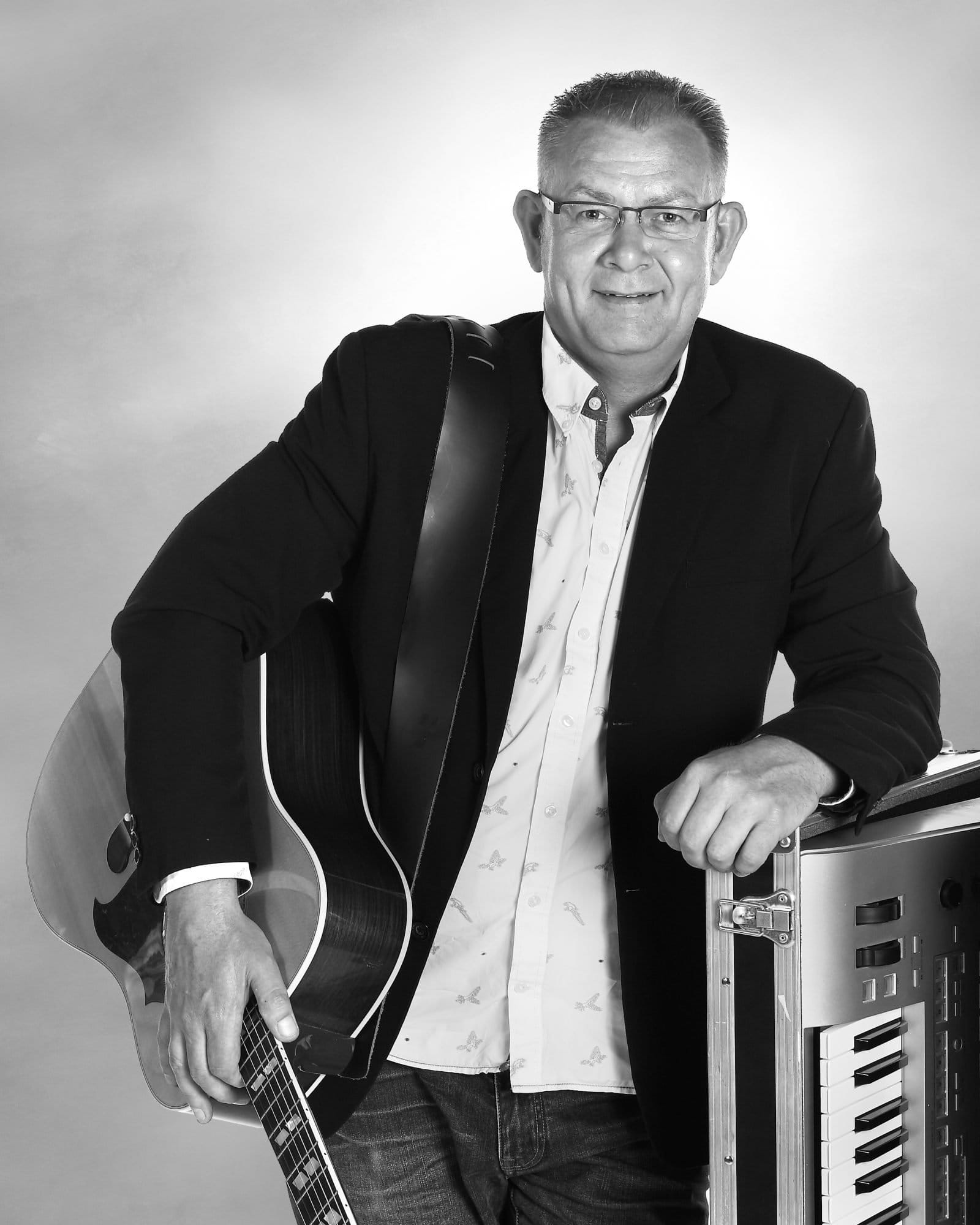 Morten Bech med sort jakke og guitar