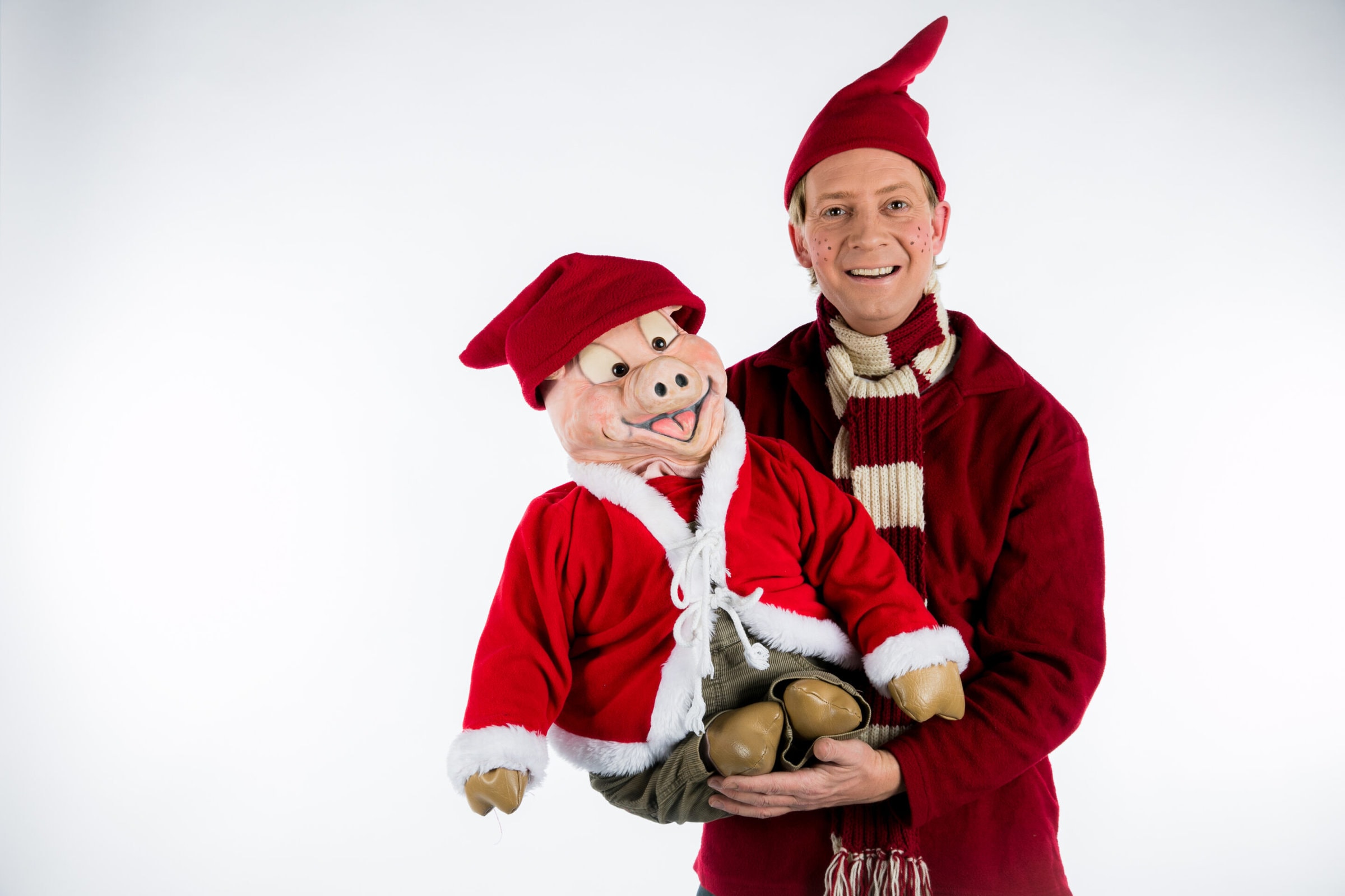 Nissen Niller i nissetøj og holder en gris