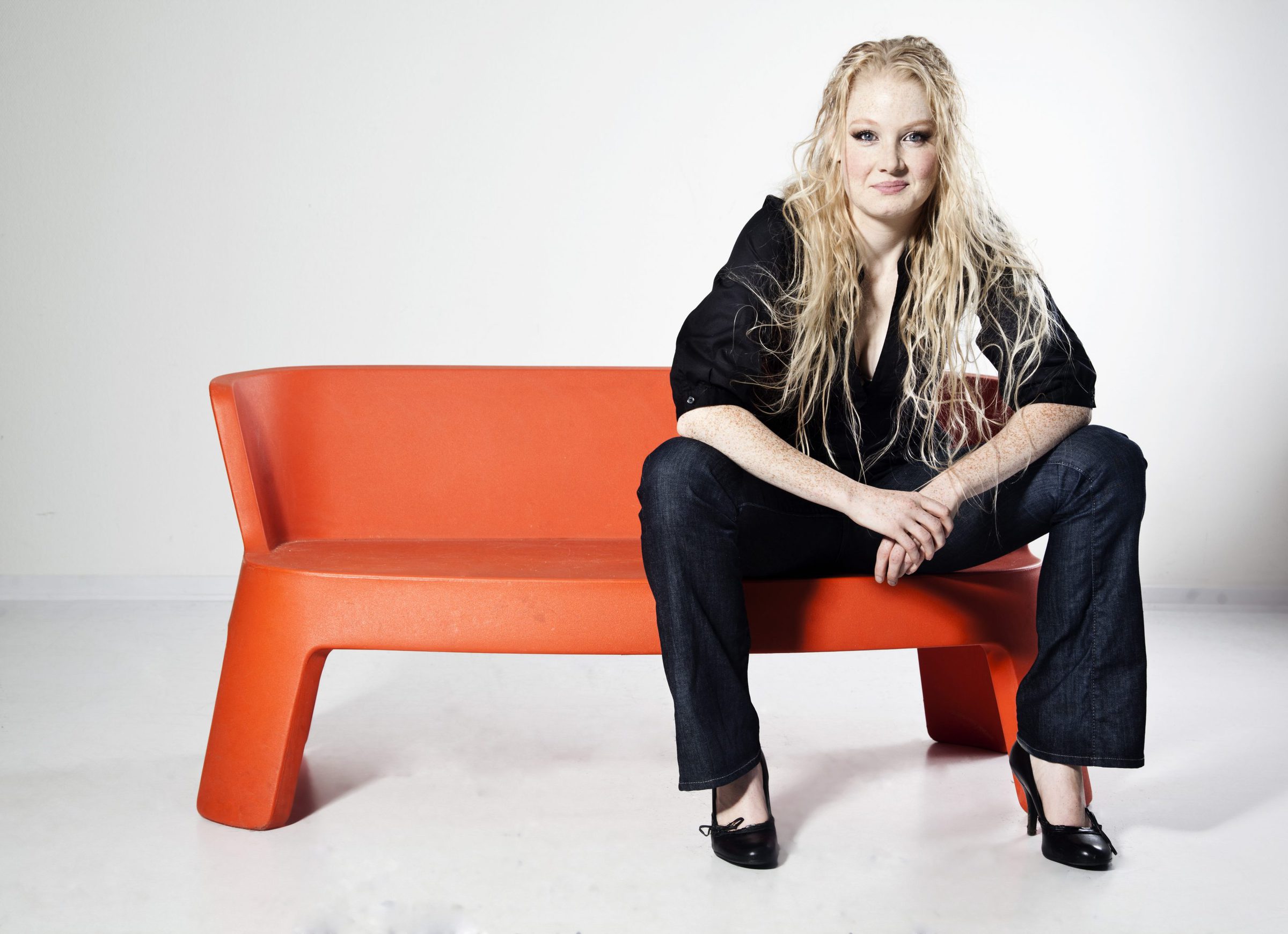 Sanne Søndergaard siddende på orange møbel