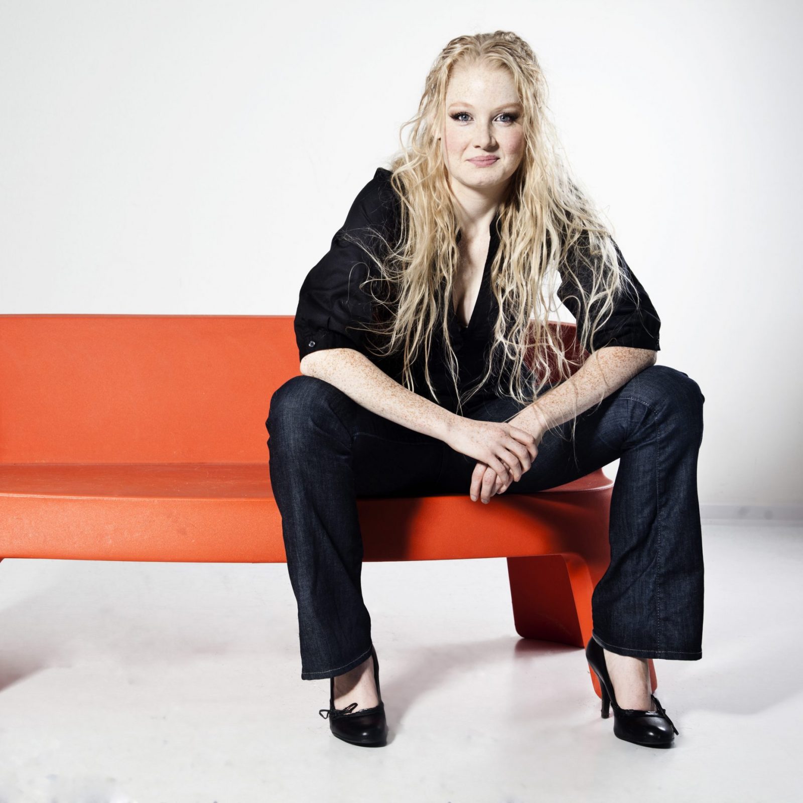 Sanne Søndergaard siddende på orange møbel