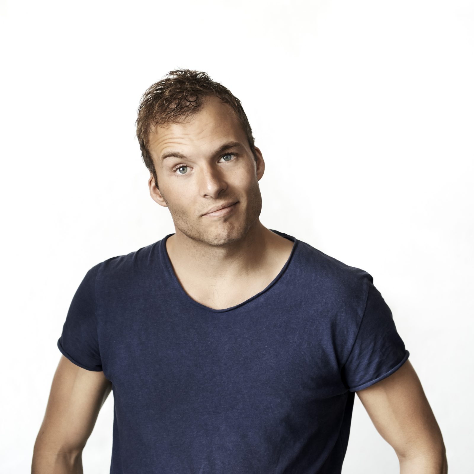 Simon Talbot med blå T-shirt foran hvid baggrund