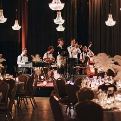 The Great Gatsby Band på scene ved dækkede middagsborde