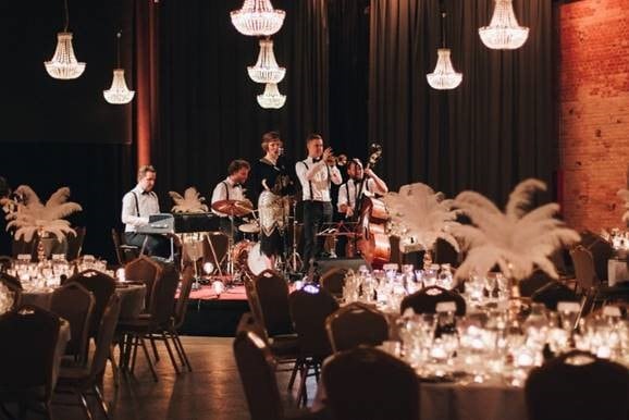 The Great Gatsby Band på scene ved dækkede middagsborde