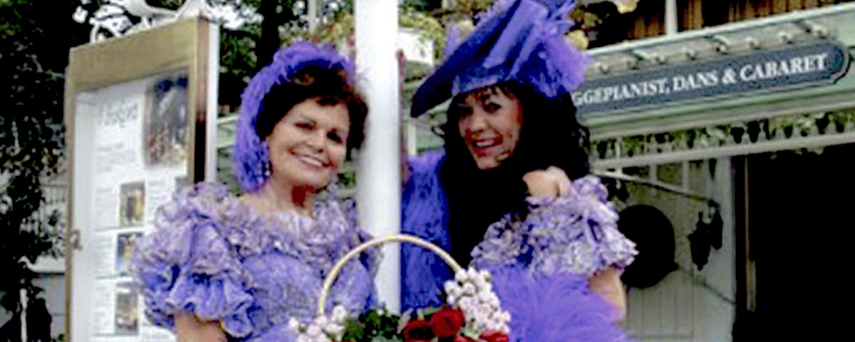To kvinder stående i lilla kjole