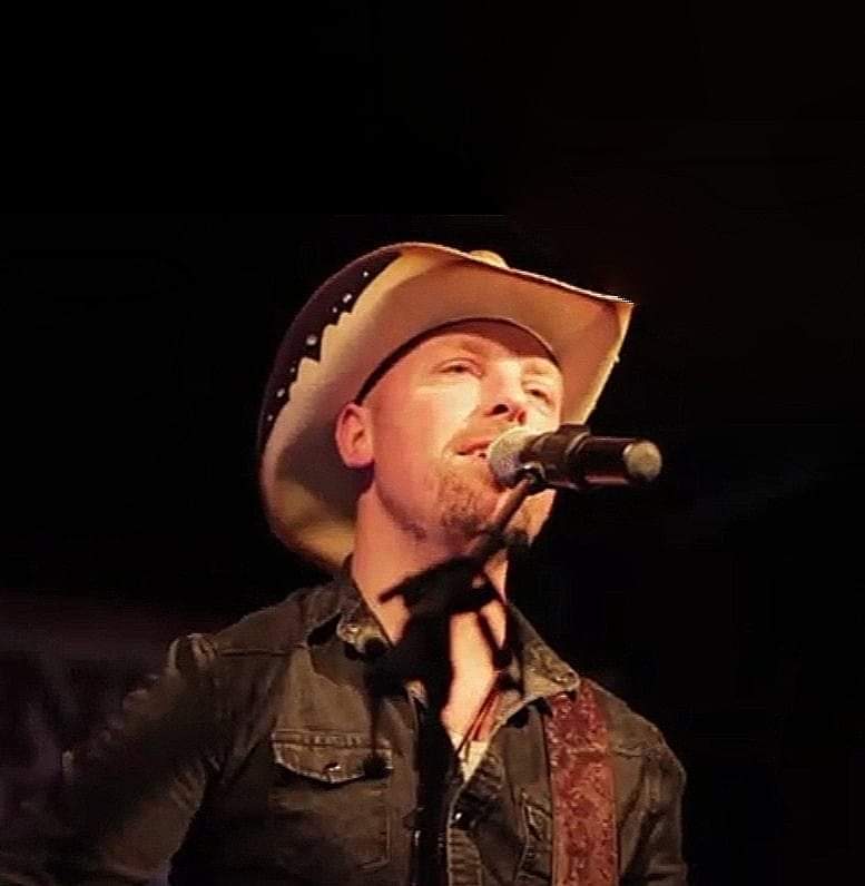 Mikkel Ørligur ved mikrofon og med cowboyhat