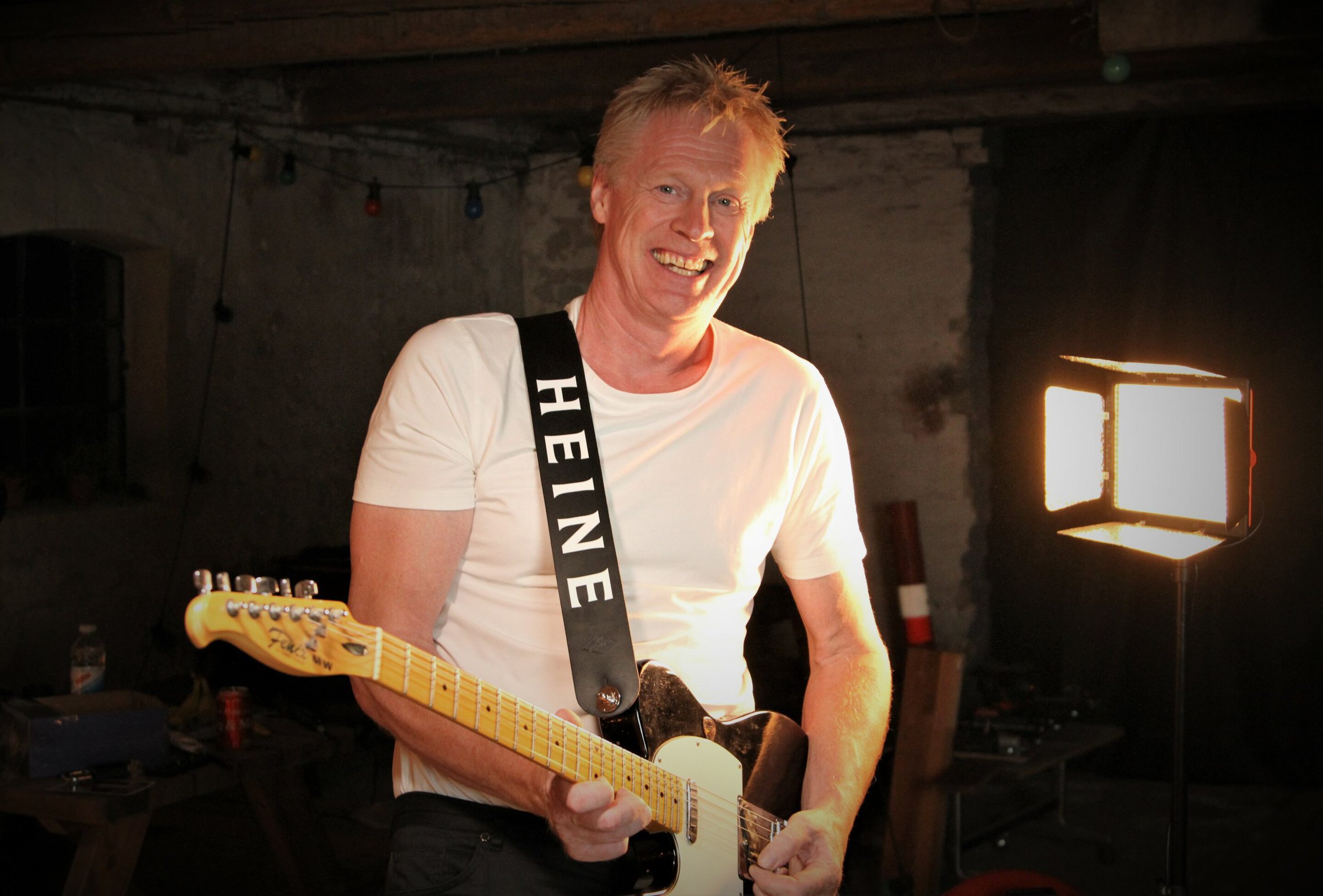 Heine spiller guitar i mørkt rum