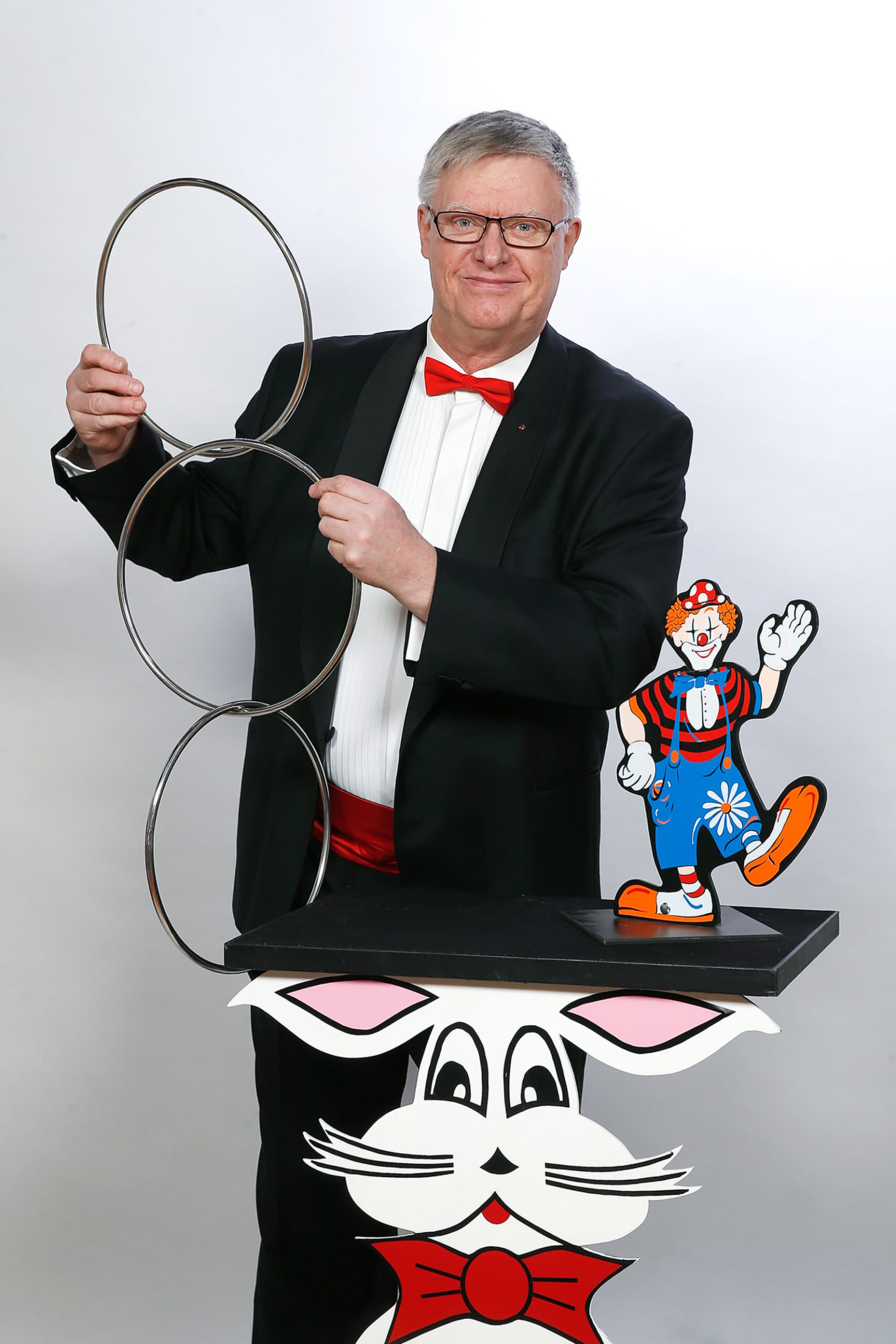 Tryllekunstneren Kurt Flemming står ved bord og holder ringe